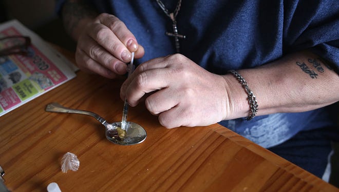 A heroin user prepares to inject himself on March 23, 2016, in New London, Conn. Communities nationwide are struggling with the unprecedented heroin and opioid pain pill epidemic.