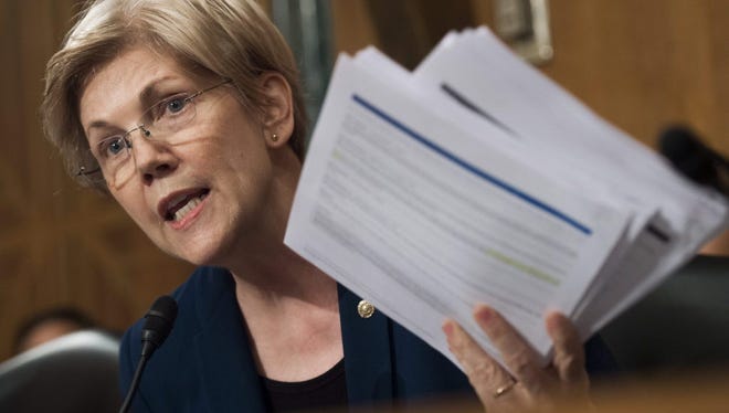US Senator Elizabeth Warren, Democrat of Massachusetts, holds up copies of Wells Fargo earnings call transcripts as she questions John Stumpf, chairman and CEO of Wells Fargo, as he testifies about the unauthorized opening of accounts by Wells Fargo during a Senate Banking, Housing and Urban Affairs Committee hearing on Capitol Hill in Washington, DC, September 20, 2016.