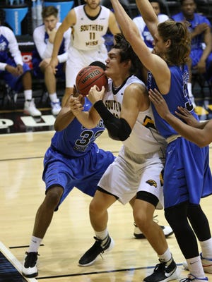 Golden Eagles' Tim Rowe battles two Georgia State players for the ball Saturday at USM.