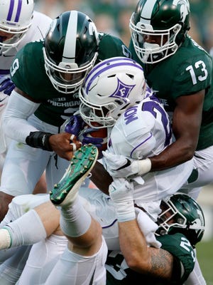 Michigan State's Montae Nicholson, left, Vayante Copeland (13) and Chris Frey, bottom right, tackle Furman's Darius Morehead, center, during the second quarter of MSU's win Friday in East Lansing.