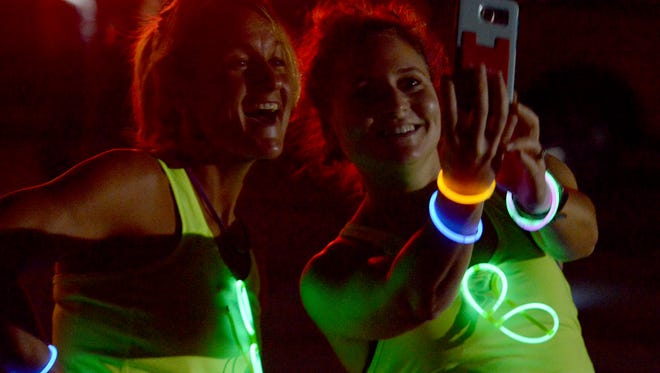 Julie Carter and Margaret Livingston take a selfie during the 2015 Leadership Jackson Impact Glow Run at Liberty Garden Park & Arboretum.