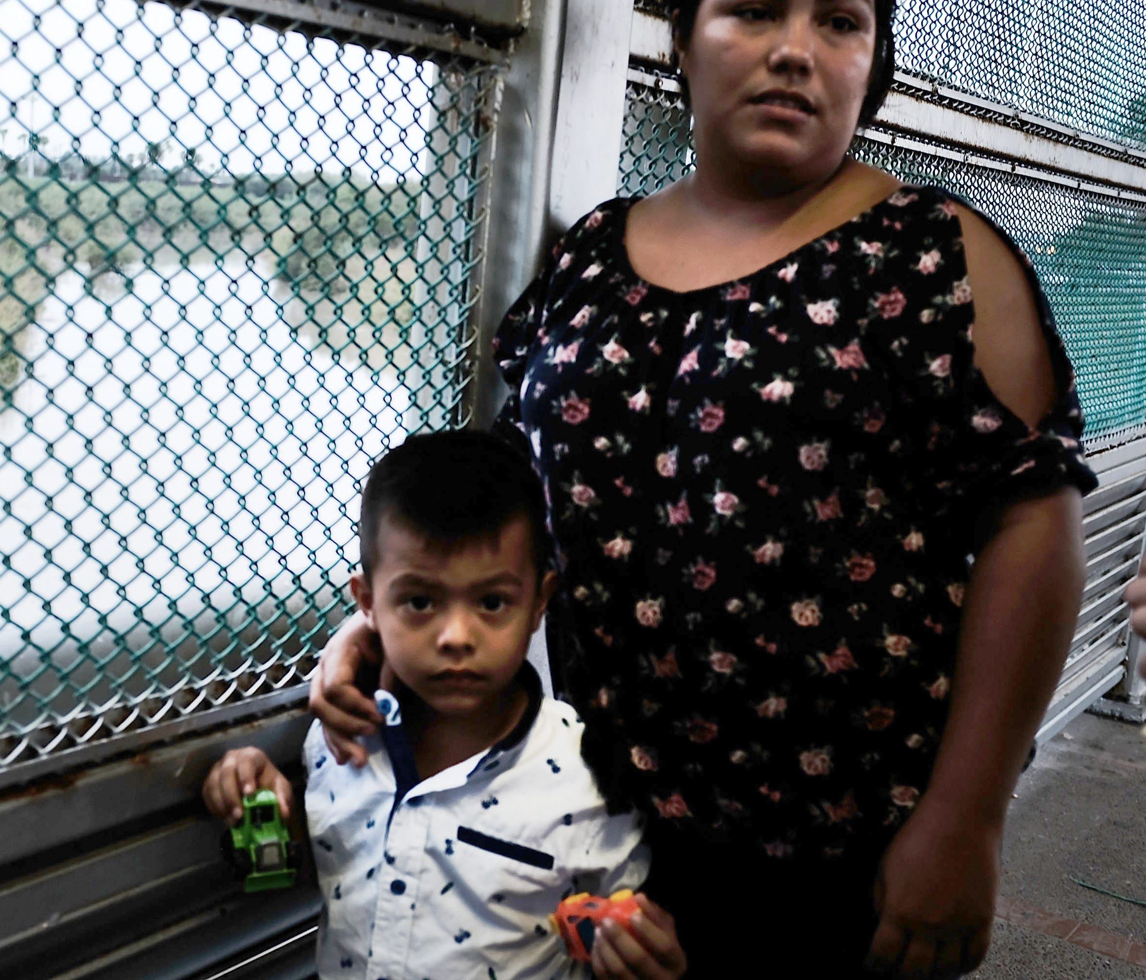 A Mexican woman and her child are held up by the border patrol as they try to enter into Brownsville on June 21, 2018 in Brownsville, Texas.