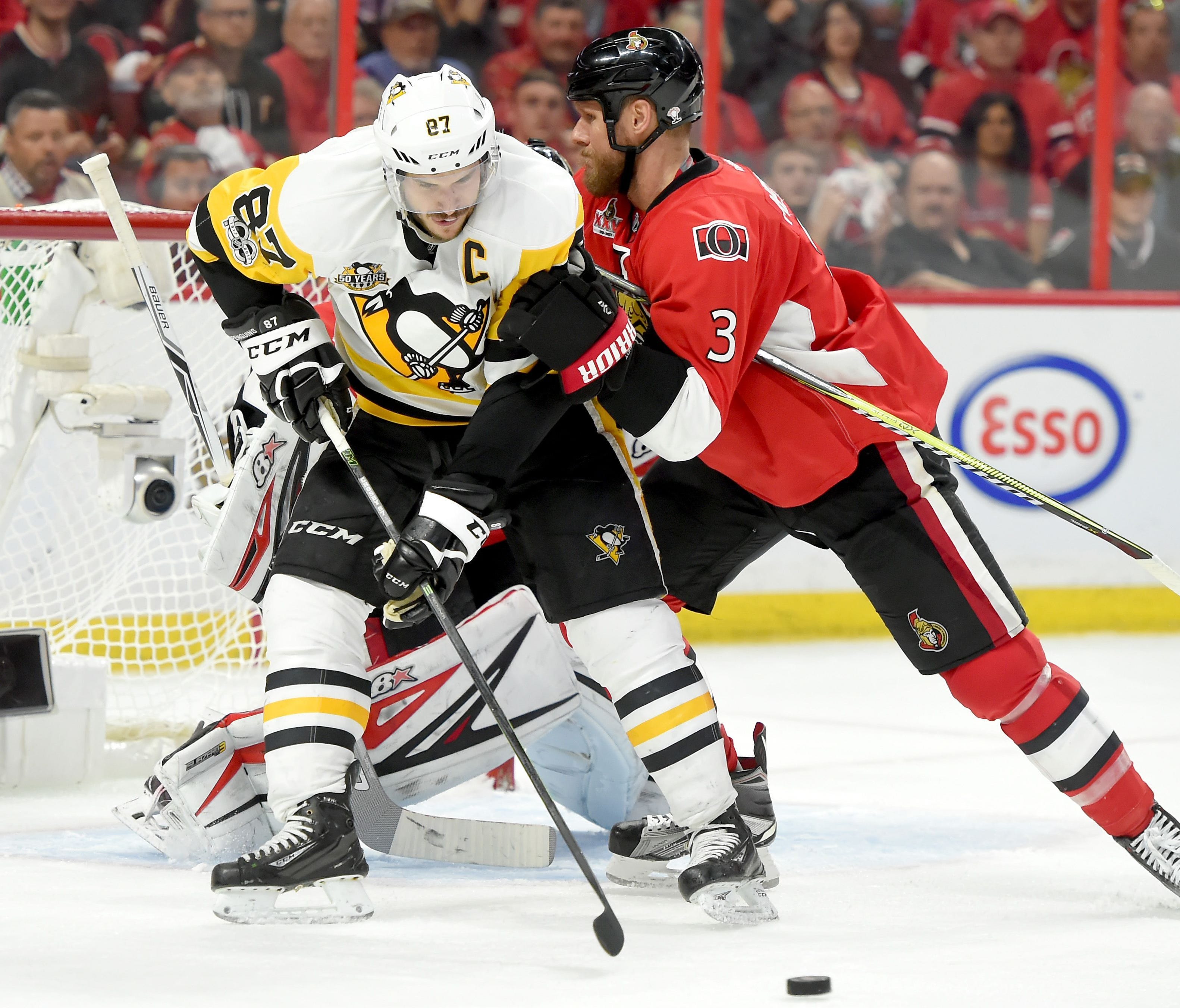 Pittsburgh Penguins forward Sidney Crosby (87) tries to control the puck as Ottawa Senators defencemen Marc Methot (3) attempts to push him aside in Game 6 of the Eastern Conference final.