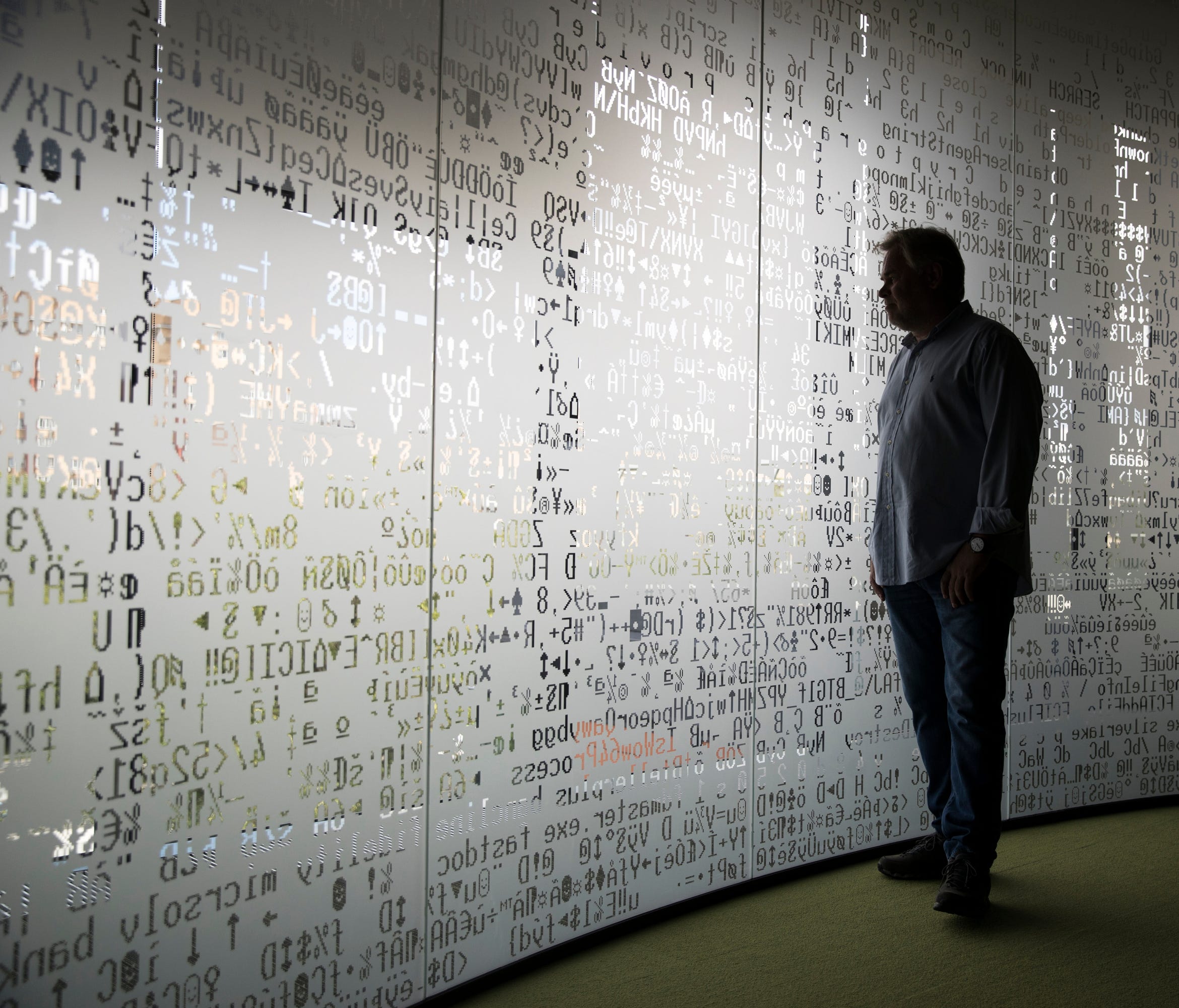Eugene Kaspersky, Russian antivirus programs developer and chief executive of Russia's Kaspersky Lab, watches trough a window decorated with programming code's symbols at his company's headquarters in Moscow, Russia, Saturday, July 1, 2017. Kaspersky