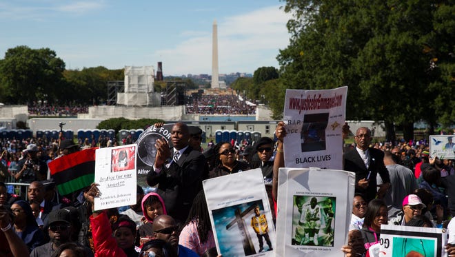 People cheer during a rally to mark the 20th anniversary of the Million Man March, on Capitol Hill, on Oct. 10, 2015, in Washington.
