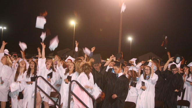 Fernley High School graduates toss their caps into the air following Friday night’s graduation ceremony.