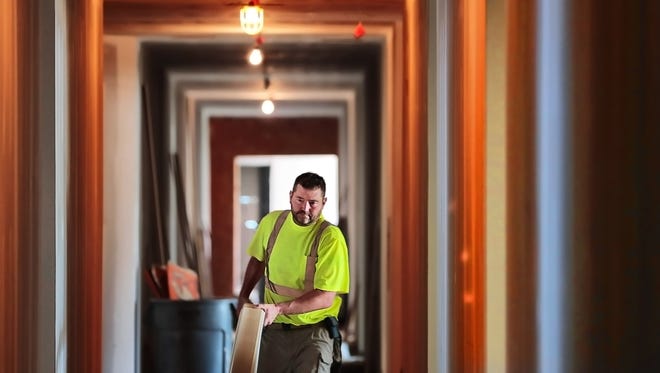 Robert Crouse works on the baseboard and trim molding in apartments at the new Thornwood mixed-use development on Germantown Road. Construction at the 17-acre, $100 million development is expected to continue for another 18 months.