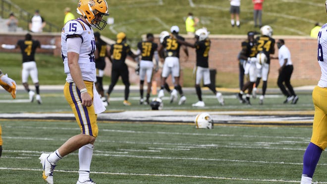 LSU quarterback Myles Brennan heads off the field as members of the Missouri Tigers celebrate an LSU turnover on downs in the final seconds of their game Saturday in Columbia, Mo. Missouri upset LSU 45-41.