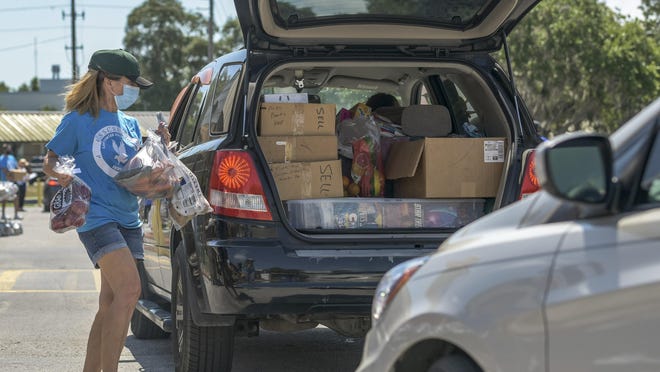 A woman puts groceries in a car at a food drop at Lake-Sumter State College in Leesburg on Thursday, May 21, 2020.