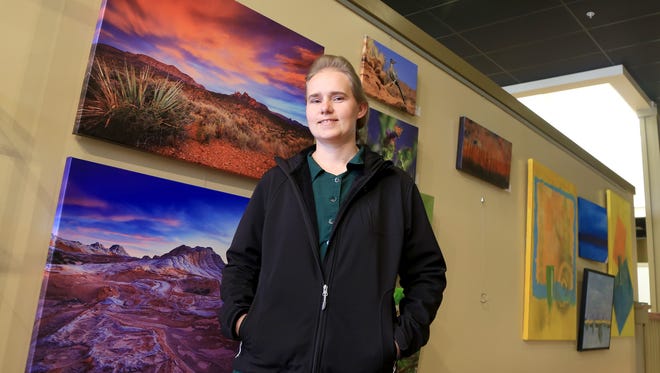 Maria Jeffs, a photographer from Hildale, stands in front of her work in the Arrowhead Gallery at the Electric Theater in St. George.