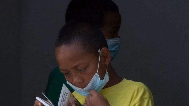 In this Oct. 10 file photo, a girl wears a face mask inside a hospital in Madagascar. Action Against Hunger said Monday that 102 plague deaths have been reported since the outbreak began in August.