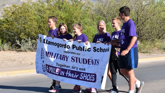 Military children walk the banner down Cuba Avenue during the parade.