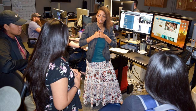 Kathryn-Mae Eiland, graphic designer at New Mexico State University's College of Agricultural, Consumer and Environmental Sciences, talks to Native American high school students about creating Internet educational games during the DreamKeepers program tour of the Innovative Media Research and Extension design studio.