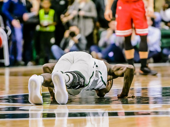 Senior Eron Harris of MSU kisses the Spartan at mid-court
