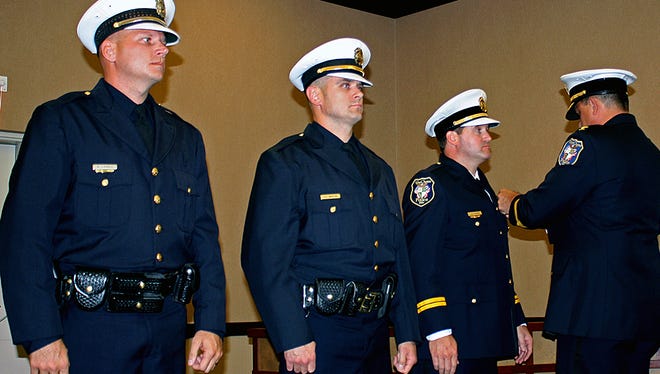 West Chester Township Police Chief Joel Herzog "pins" newly promoted officers, from left, Sgt. Paul "Brent" Loevell, Lt. Christopher Whitton, and Capt. Joseph Gutman.
