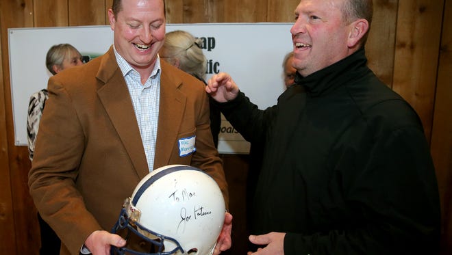 Former South Kitsap coach Eric Canton (right) gives Kitsap Sports Hall of Fame inductee Mac Morrison a Penn State helmet with late Nittany Lions coach Joe Paterno's autograph at Kiana Lodge in Suquamish on Saturday.