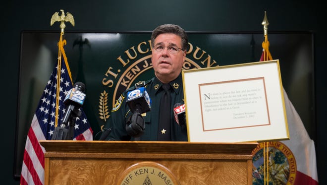 St. Lucie County Sheriff Ken J. Mascara reads a quote from Theodore Roosevelt that hangs on his office wall before giving a news conference on Wednesday, Jan. 25, 2017, at the St. Lucie County Sheriff's Office in Fort Pierce. Mascara informed the media that deputy Evan Cramer had been arrested on charges of sexual battery.  Cramer, who was on duty at the time of the incident, indicated this was not the only occurrence.
