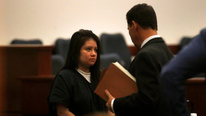 Charmaine Lucero talks to defense attorney Matthew Cockman Thursday at District Court in Aztec. Lucero's sentencing for a February 2015 shooting was delayed.