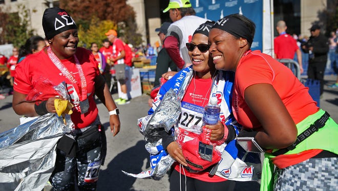 Sandra Sears, from left, Gigi Lewis-Benbow, and Mecca Plunkett , friends with Black Girls Run, celebrate finishing their races at the Indianapolis Monumental Marathon, Saturday, November 7, 2015.  