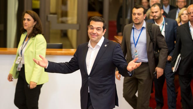 Greek Prime Minister Alexis Tsipras, center, leaves the building after an emergency summit of eurozone heads of state or government in Brussels on Tuesday, July 7, 2015.