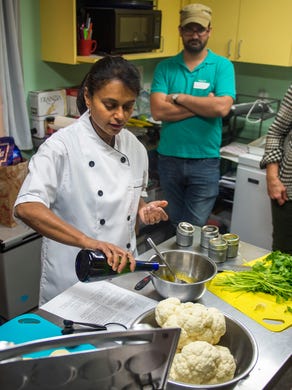Chef Jes Thomas, center, demonstrates during a Taste of India cooking demonstration at the Central Collective in Knoxville on Sunday, Dec. 11, 2016. 