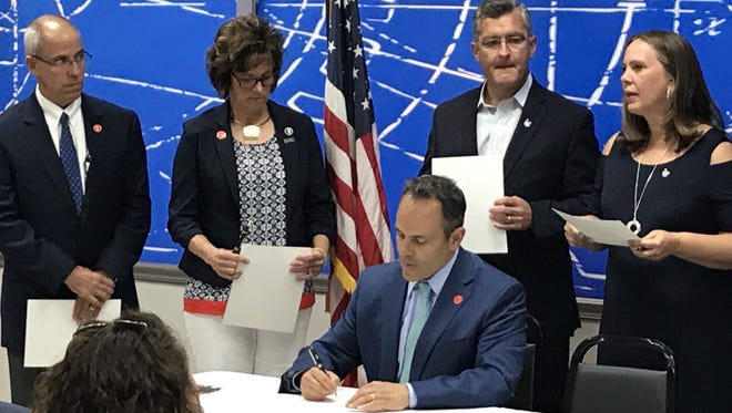 Gov. Matt Bevin ceremonially signs House Bill 184 surrounded by state and local officials Wednesday at Gibbs Die Casting in Henderson.