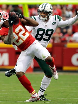 Kansas City Chiefs defensive back Marcus Peters (22) intercepts a ball intended for New York Jets wide receiver Jalin Marshall (89) for a turnover during the first half of an NFL football game in Kansas City, Mo., Sunday, Sept. 25, 2016.