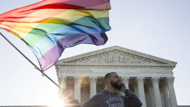 Marriage equality supporter Vin Testa, of Washington, DC, waves a rainbow pride flag near the Supreme Court, April 28, 2015 in Washington, DC.