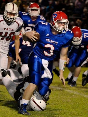 Pace Patriots QB, Ashton Stephens, simplies runs over a Tate Aggies defender while picking up yardage around the end of the Tate Aggies defense during their game Friday night at Pace.