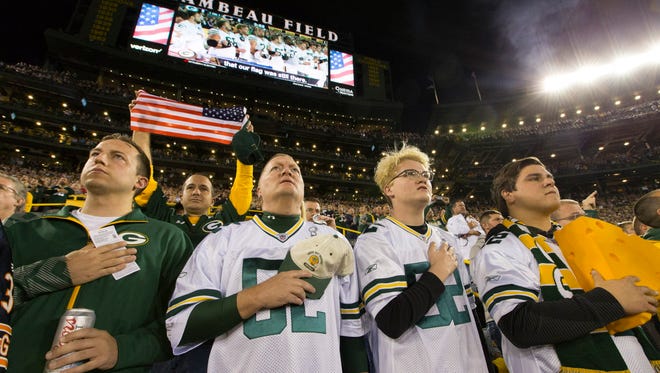 Scott Sheffield (second from left) and his sons, Connor and Spencer, stand for the national anthem before the Green Bay Packers game against the Chicago Bears on Thursday at Lambeau Field in Green Bay. The family from St. George, Utah, said they weren't going to lock arms because that gesture seemed more like an anti-President Trump protest. To demonstrate unity, Green Bay Packers quarterback Aaron Rodgers asked fans to join players, locking arms in the stands during the national anthem.