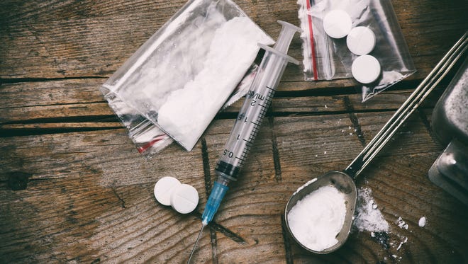 Drug, syringe and heroin on grunge wooden background