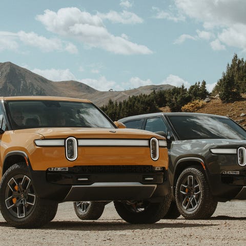 Two Rivian trucks parked side by side.