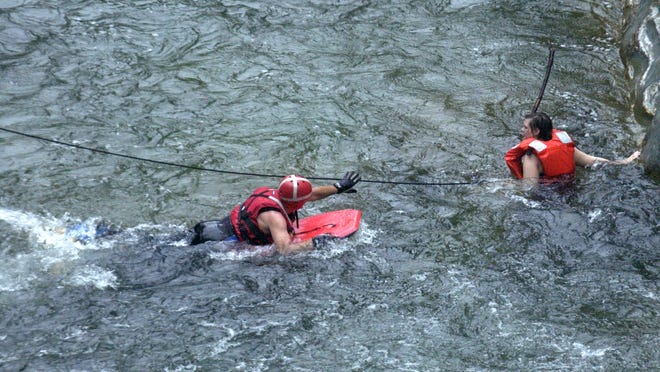 Mike Cannon of Colchester Technical Rescue swims across the Huntington River to recue Britt Pristow of Burlington at the Huntington Gorge in Richmond on June 9, 2004. Pristow was pulled over a set of falls while swimming with friends.
