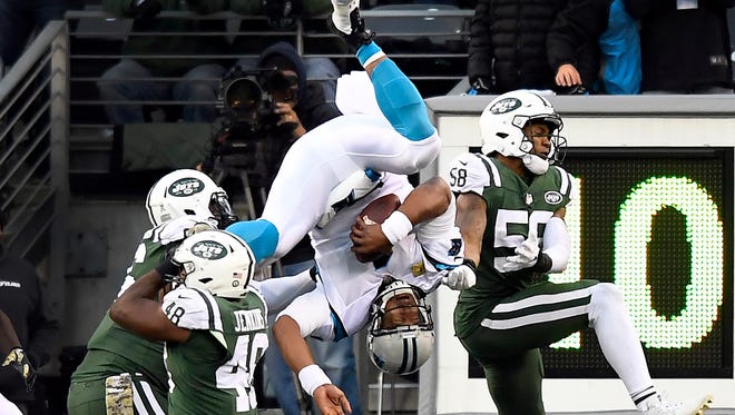 Carolina Panthers quarterback Cam Newton flips into the air after a hit by New York Jets outside linebacker Jordan Jenkins (48). Jets lost 35-27 on November 26, 2017 in East Rutherford, NJ.