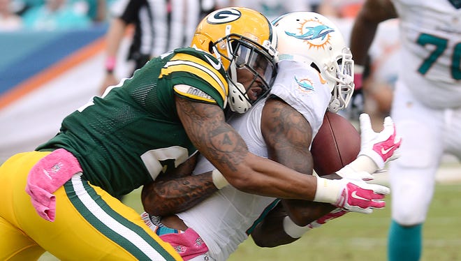 Green Bay Packers safety Ha Ha Clinton-Dix (21) lays a hit on receiver Mike Wallace (11) knocking the ball loose against the Miami Dolphins at Sun Life Stadium.