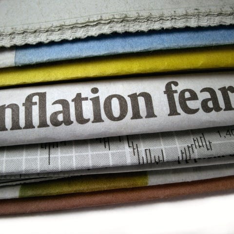 stack of newspapers with headline of inflation fea