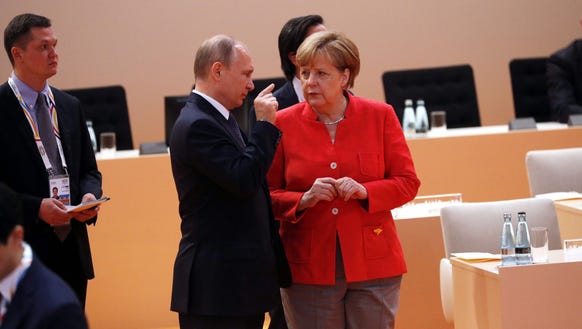 German Chancellor Angela Merkel talks to Russia's President