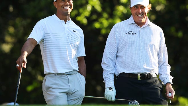 Tiger Woods, left, and Phil Mickelson share a laugh on the 11th tee box while playing a practice round for the Masters golf tournament at Augusta National Golf Club in Augusta, Ga., Tuesday, April 3, 2018. (Curtis Compton/Atlanta Journal-Constitution via AP)