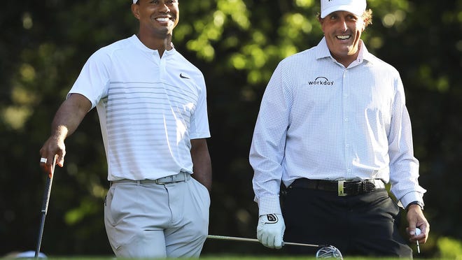 In this 2018 photo, Tiger Woods and Phil Mickelson share a laugh on the 11th tee box during a practice round for the Masters. The two will face off this weekend  in The Match: Champions for Charity at Medalist Golf Club in Hobe Sound.