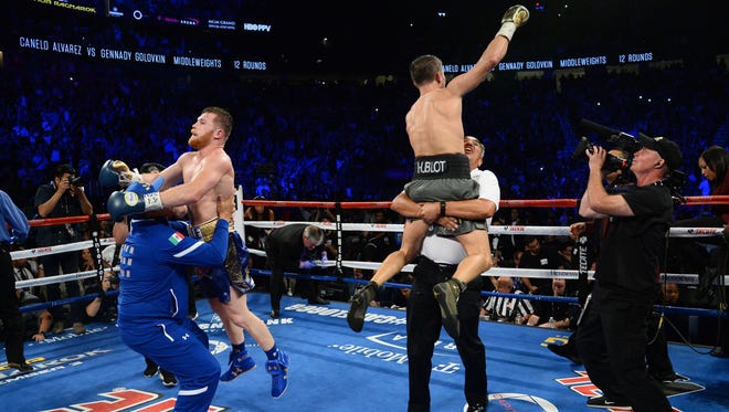 Sept. 16: Gennady Golovkin (green trunks) and Canelo Alvarez (blue trunks) celebrate after their middleweight championship bout at T-Mobile Arena. The highly anticipated matchup ended in a draw.