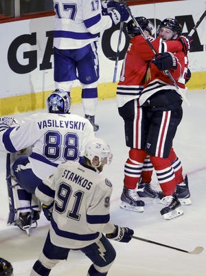 The Blackhawks’ Brandon Saad, right, is congratulated by teammate Brad Richards after scoring past Lightning goalie Andrei Vasilevskiy (88) and Steven Stamkos (91) during the third period of Game 4.