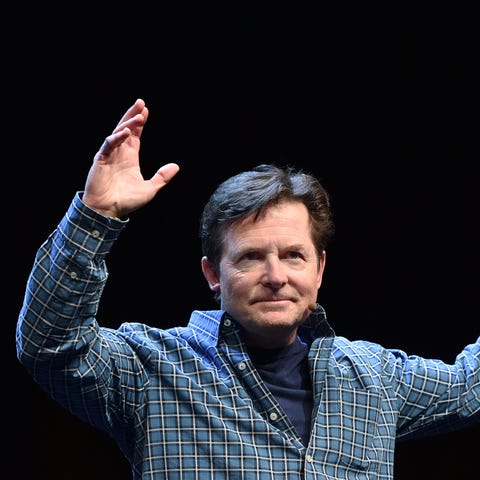 Michael J. Fox waves to a cheering crowd before a...