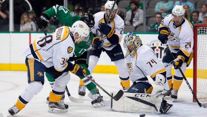 Stars center Devin Shore fights for the puck with Predators right wing Viktor Arvidsson and goalie Juuse Saros during the first period on April 6, 2017.