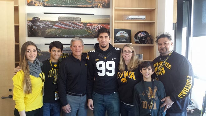 A.J. Epenesa (99), pictured with his family and Iowa coach Kirk Ferentz, committed Sunday to the Hawkeyes.