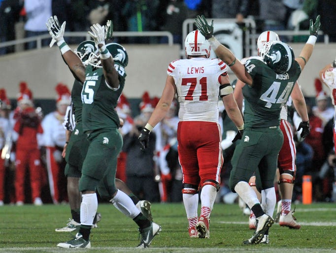 Darien Harris, left, and Marcus Rush right of Michigan State celebrate after pressuring Nebraska quarterback Tommy Armstrong Jr. into throwing an interception in the final seconds of the game on Saturday, Oct. 5, 2014 at Spartan Stadium in East Lansing, Mich. The Spartans won, 27-22.