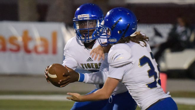 Martin County quarterback George Johnson fakes a handoff to Vincent Lapolla during the first half against Melbourne. Johnson had a hand in all six of Martin County's touchdowns