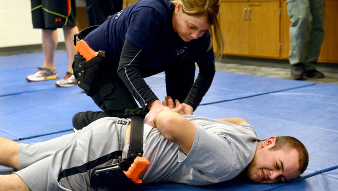 Lisa Brown, of Cambridge, practices takedown techniques with fellow student Scott Cunningham, of Quaker City, on Jan. 9 as part of the Zane State College Police Academy program in Zanesville.