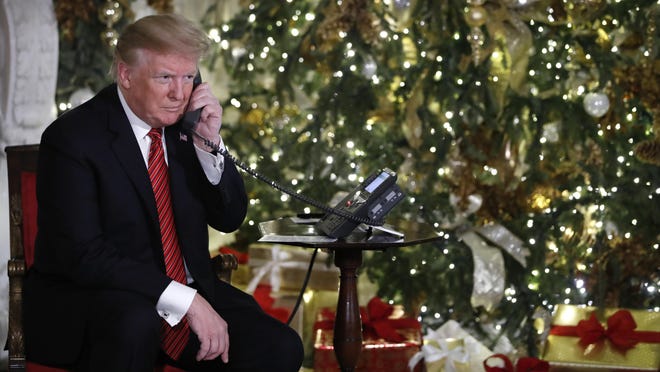 President Donald Trump listens on the phone as he shares updates to track Santa's movements from the North American Aerospace Defense Command (NORAD) Santa Tracker on Christmas Eve, Monday, Dec. 24, 2018. (AP Photo/Jacquelyn Martin)