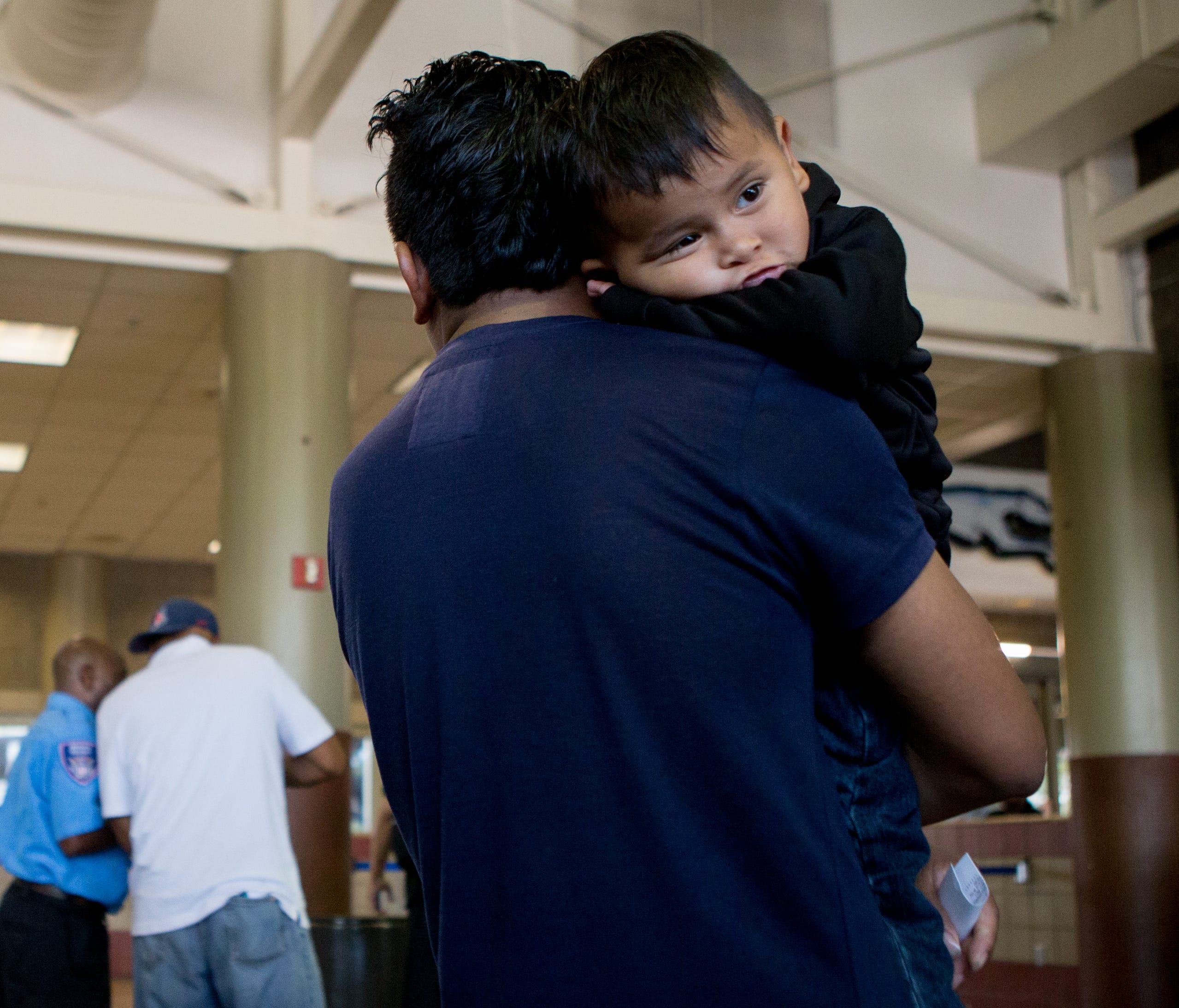 Edwin Antonio Gonzalez, 24, and his son Francisco, 2, both of Guatemala, wait to board their next bus after being released by the Department of Homeland Security on July 12, 2018, at a bus station in Phoenix.