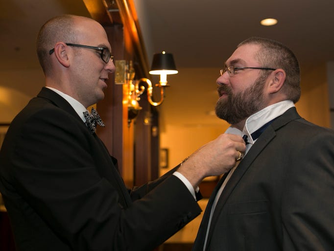 Danny Beyer, 33, left, helps out Doug Enright, 36,